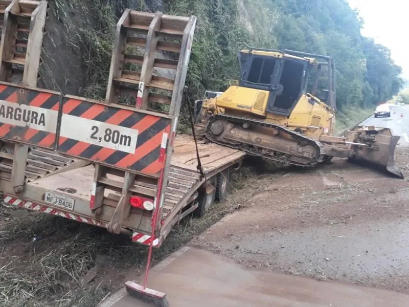 Caminhão que carregava trator colide contra barranco na BR-282